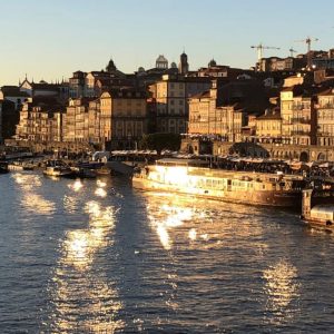 reflets dorés du coucher de soleil sur le quai d'un port avec bateaux et ville en arrière-plan