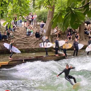 surfeurs ridant les vagues d'un canal d'eau douce dans un parc urbain