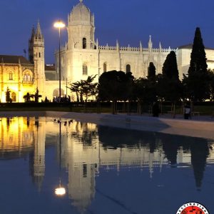 vue extérieure nocturne d'un monastère se reflétant dans l'eau d'une fontaine