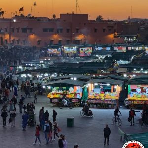 Animation et stands de nourriture éclairés sur la place Jemaa el-Fna à Marrakech lors du coucher de soleil
