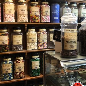 Étagères en bois remplies de bocaux en verre contenant des bonbons traditionnels colorés dans la plus vieille confiserie d'Angleterre